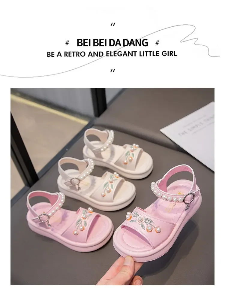Detalle de bordados y perlas en sandalias de niña