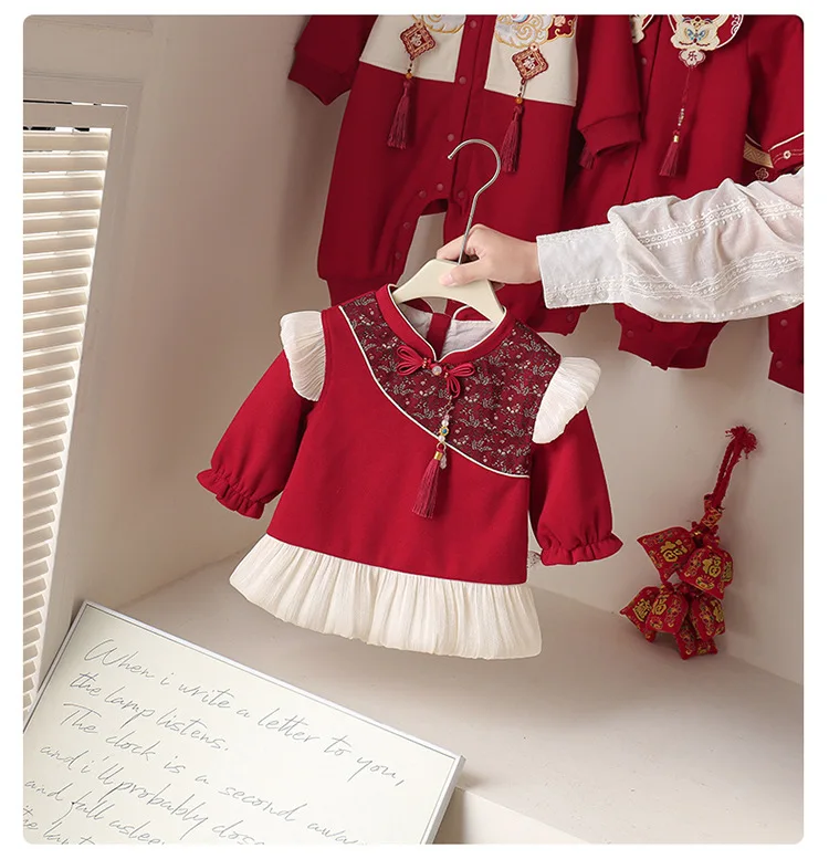 Niña pequeña posando con el vestido rojo bordado