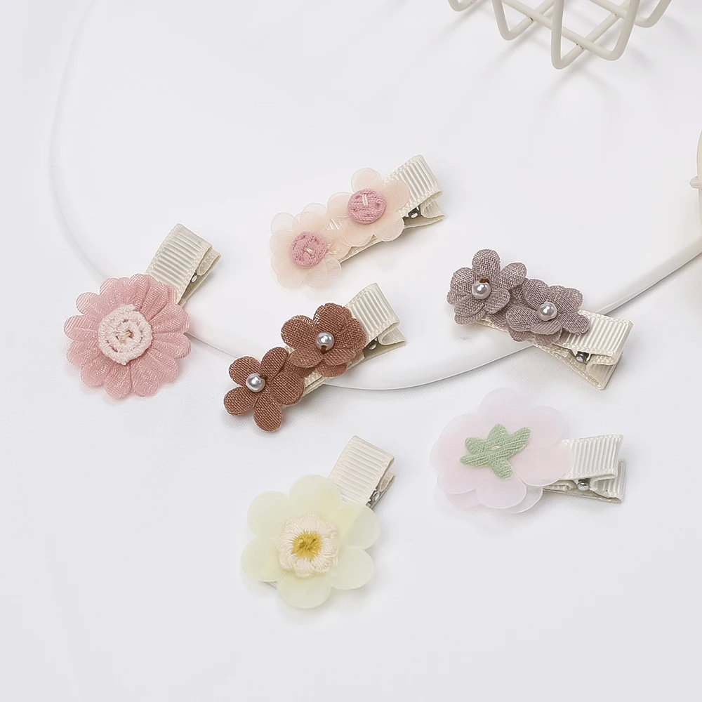 Pinzas de gasa con flores y margaritas en tonos pastel