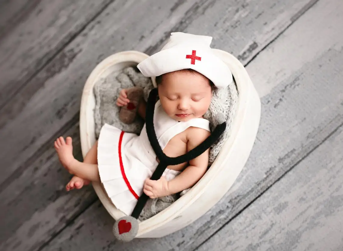 Bebé con vestido de enfermera, gorro y estetoscopio