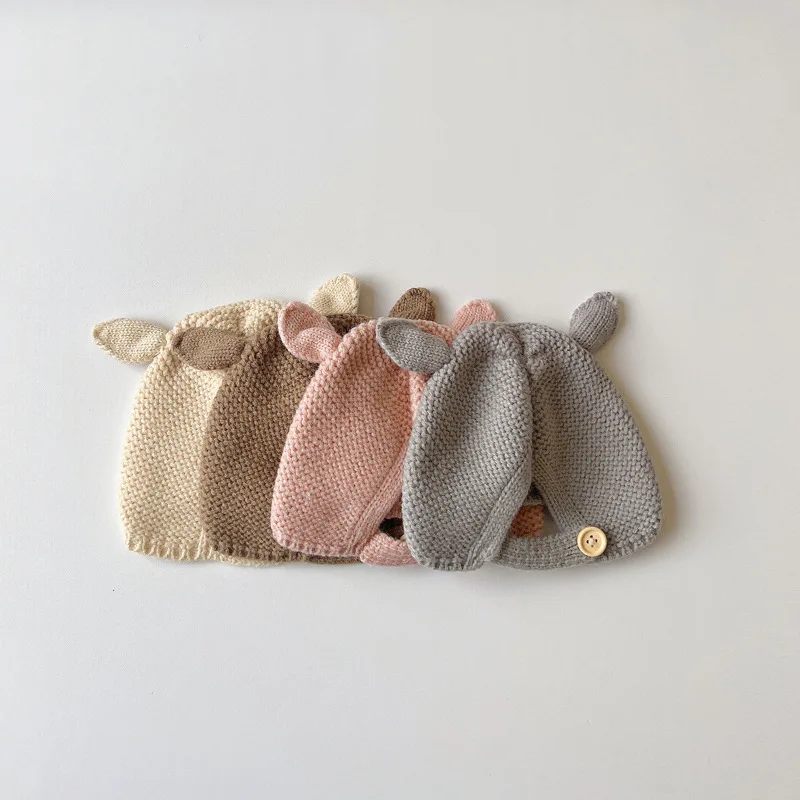 Bebé con gorro de orejas de conejo en tonos neutros