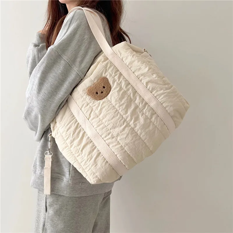 Bolsa de pañales con diseño de oso en uso como bolso de hombro