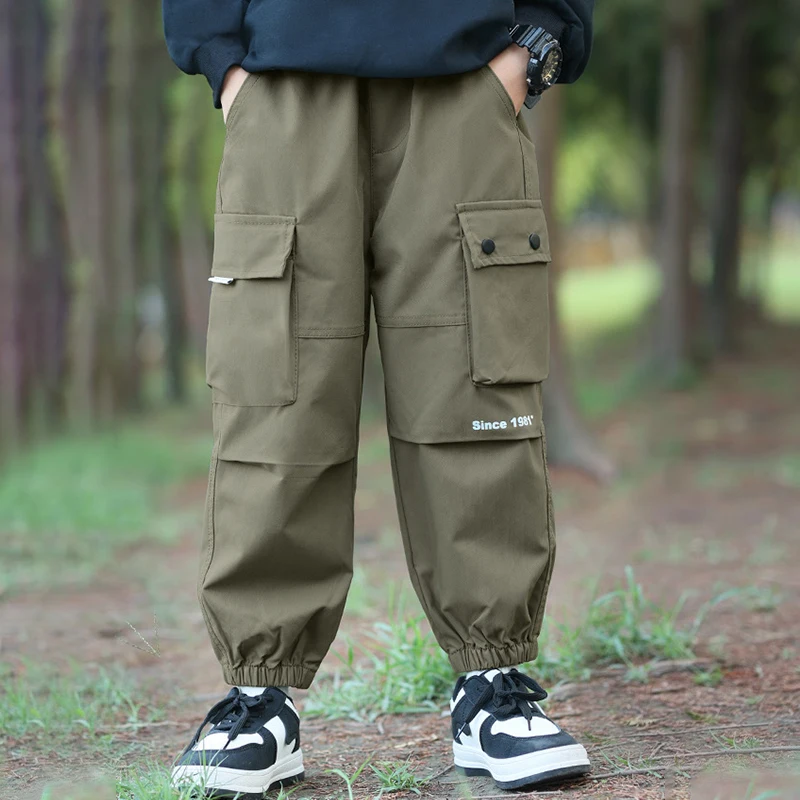 Niño jugando al exterior con los pantalones