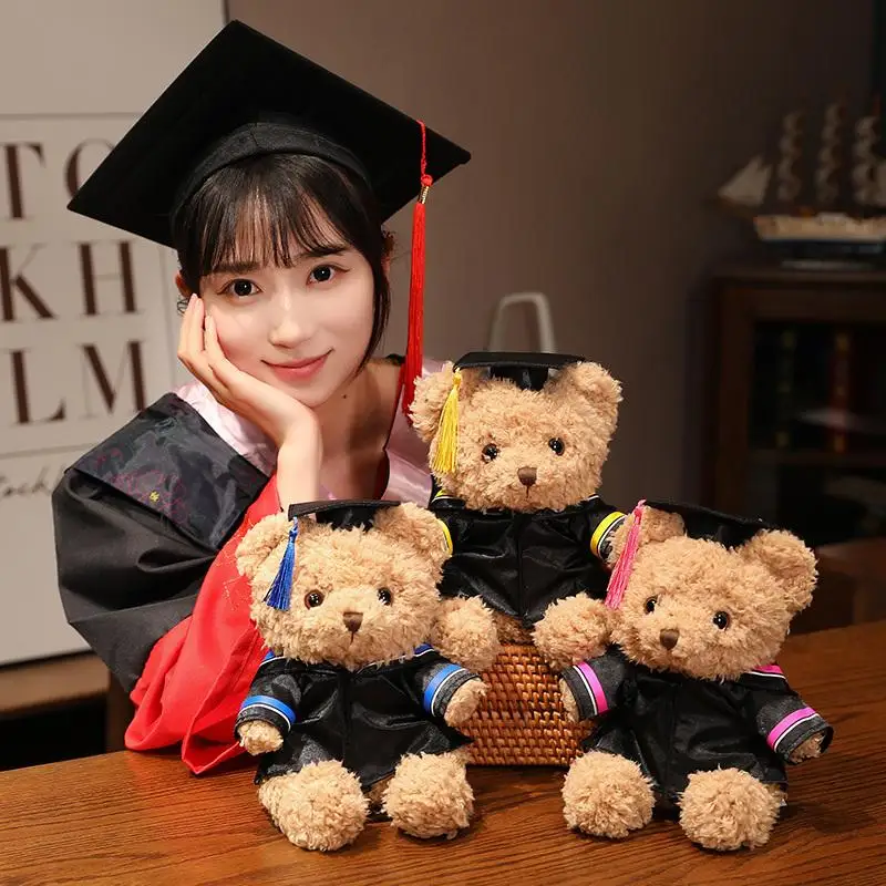 Oso de peluche graduación con bata académica, sentado