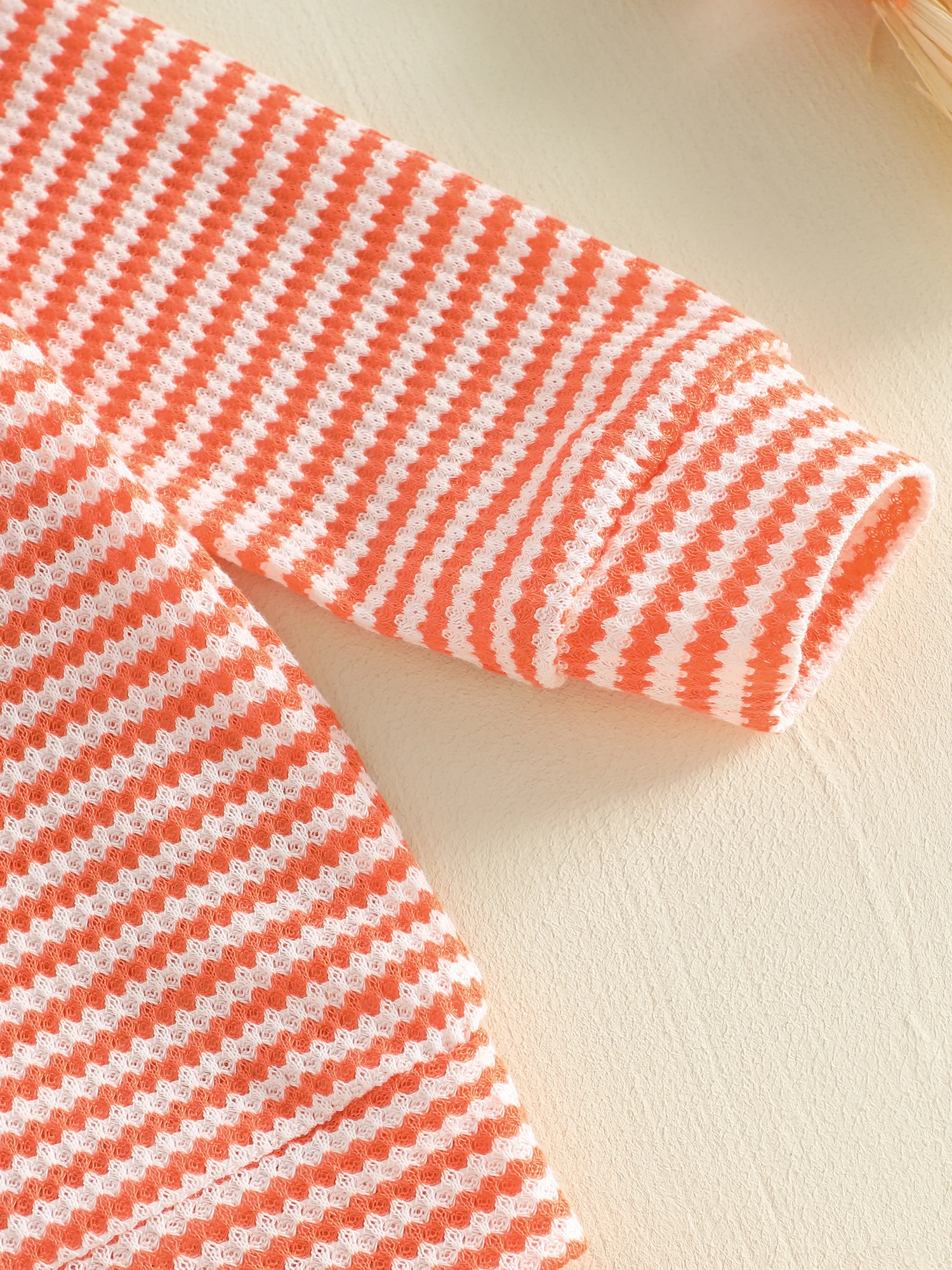 Prenda infantil en color naranja y negro