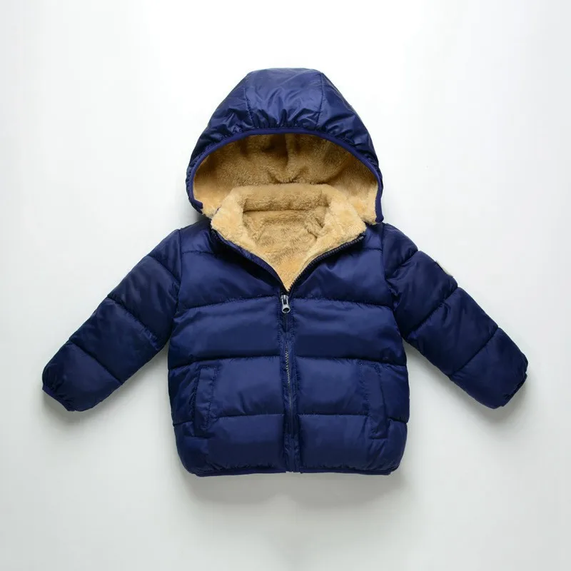 Niña llevando la chaqueta en el parque durante el invierno