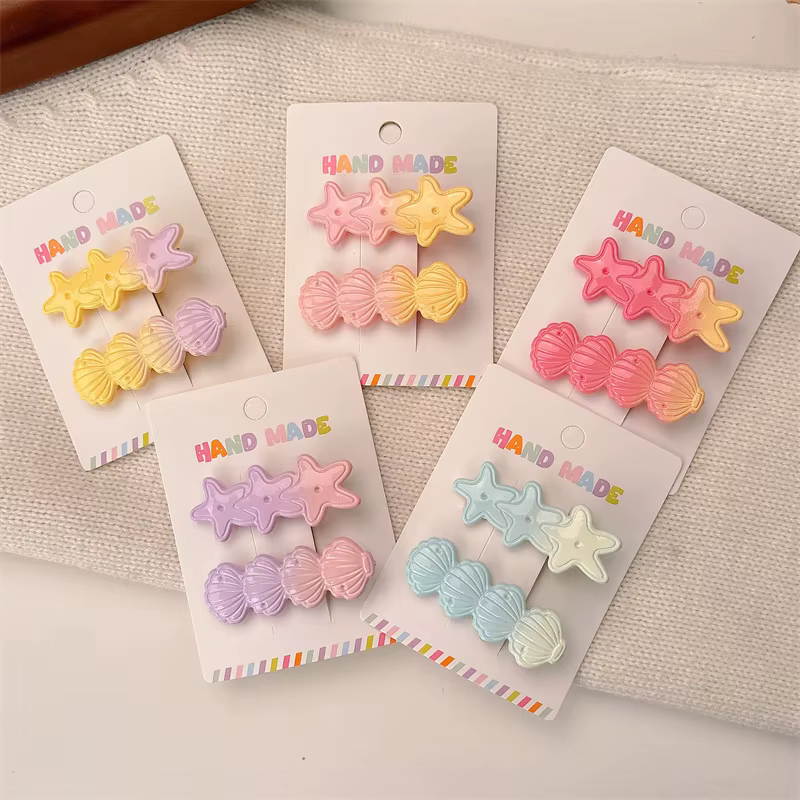 Pinza de pelo con diseño de concha y estrella de mar en tonos pastel