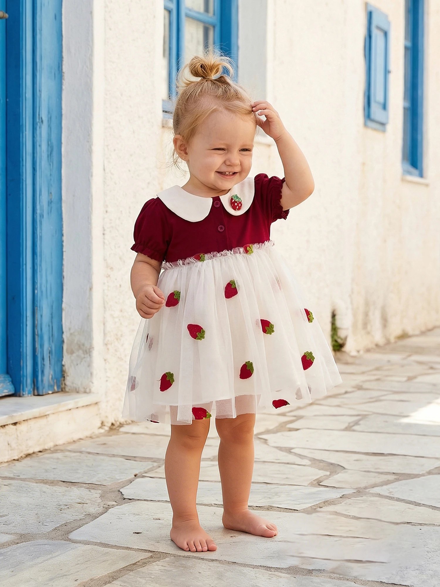 Niña vistiendo el vestido de fresa en tono rojo