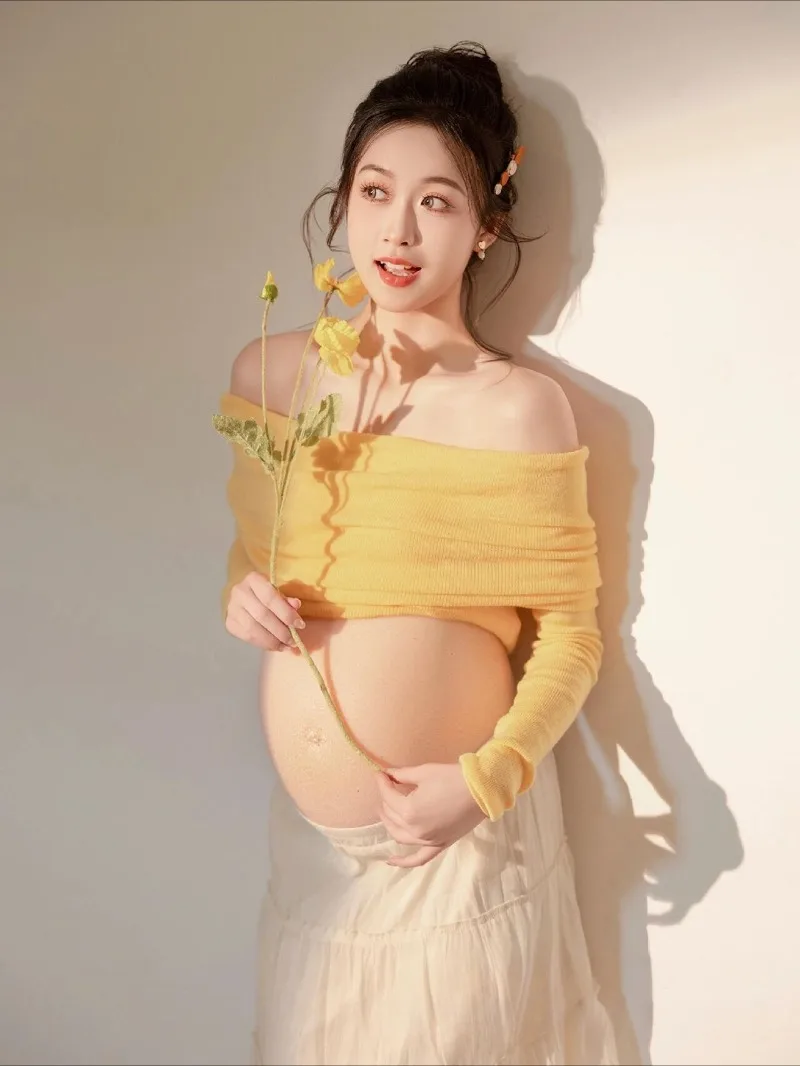 Vestido de maternidad estilo sesión de fotos con top de punto amarillo y falda blanca