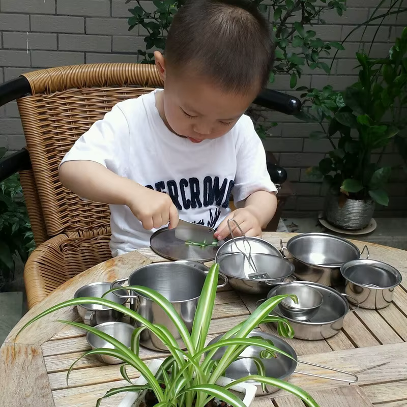 Niña jugando con utensilios de cocina infantiles