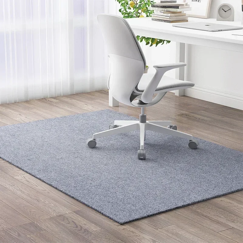 Alfombra colocada sobre suelo de madera mostrando su superficie gris y blanca