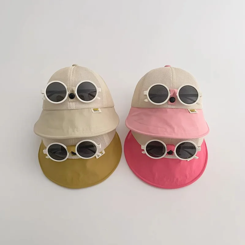 Bebé con sombrero de cubo y gafas de sol color caramelo