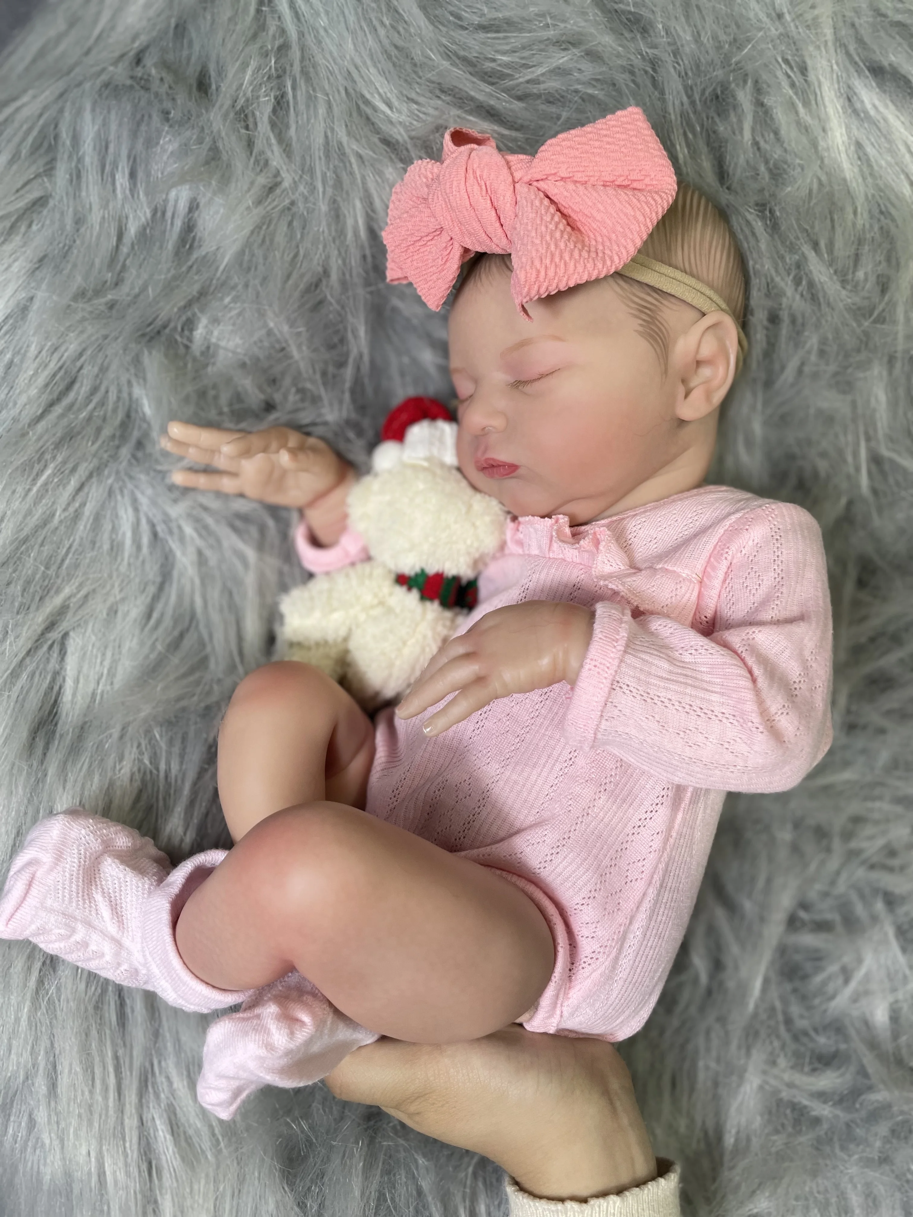 Muñeca Reborn mostrando su rostro durmiente y detalle del pelo enraizado