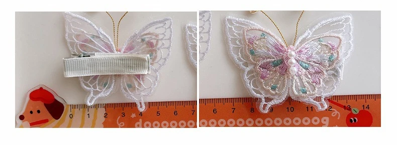 Dos clips de pelo con bordado de mariposa en tonos rosa y blanco