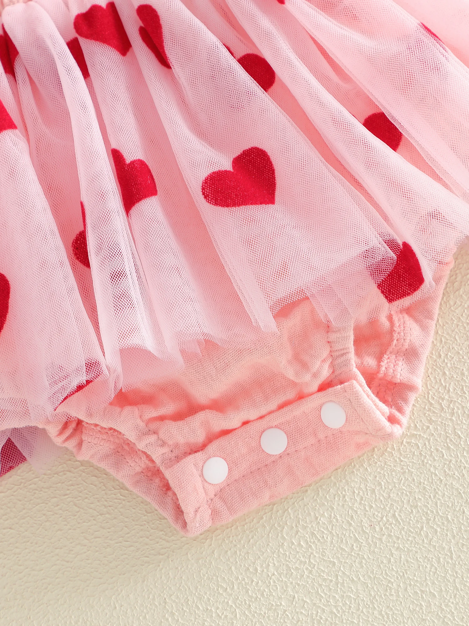 Detalle del bordado con corazón y las mangas volantes del vestido