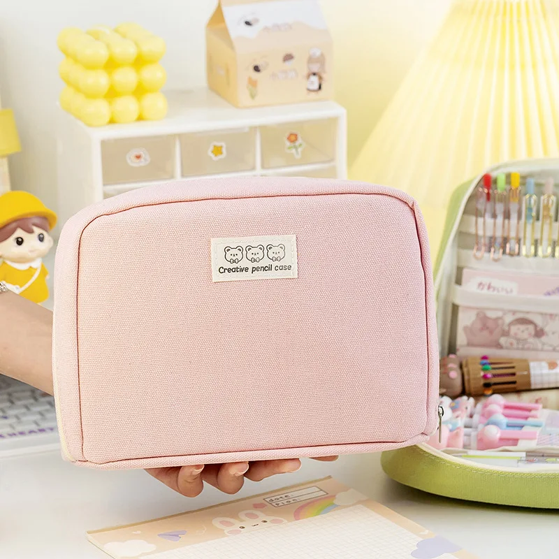 Estuche beige sobre escritorio con lápices y cuadernos