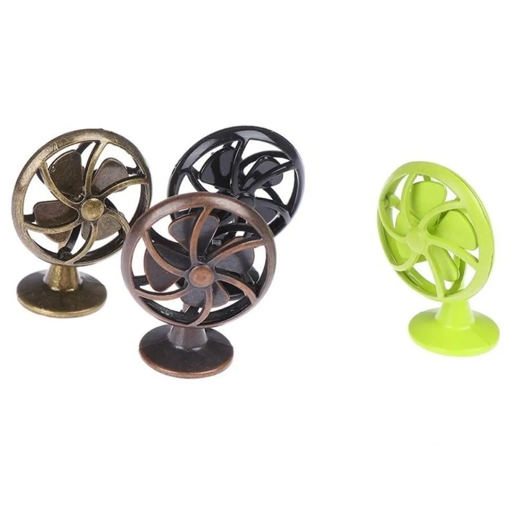 Ventilador vintage en verde colocado en estantería de muñecas