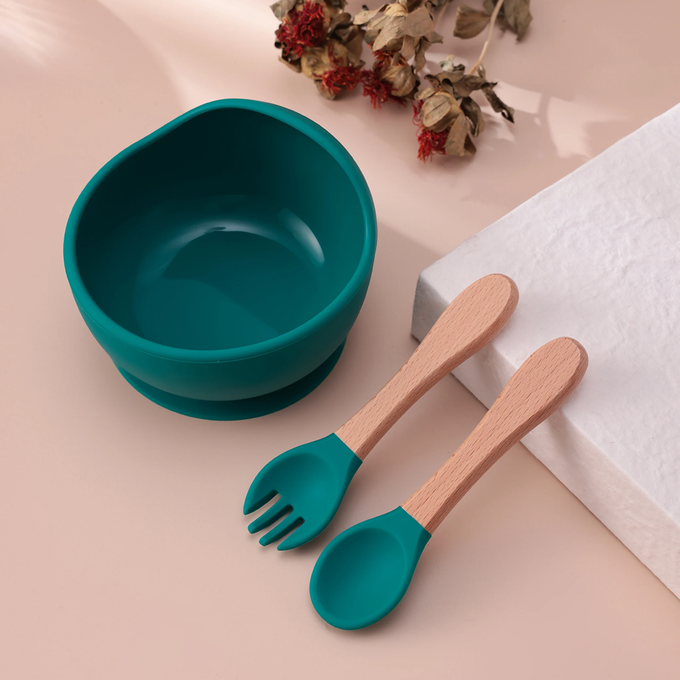 Cuchara y tenedor de madera junto al tazón de silicona azul