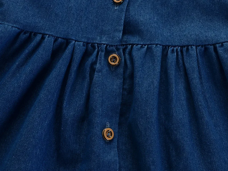 Niña con vestido azul en exterior