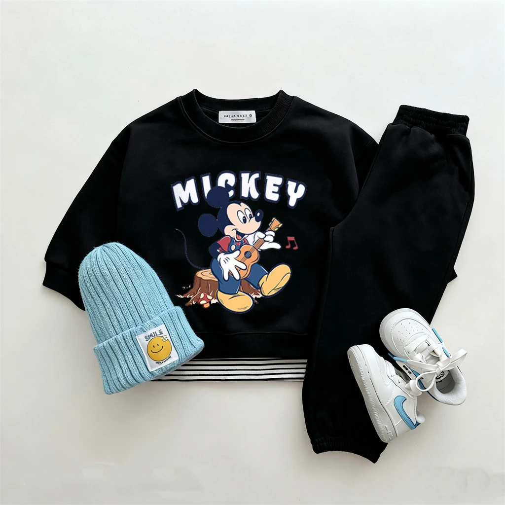 Niño vistiendo conjunto Disney de sudadera con personaje y pantalón negro