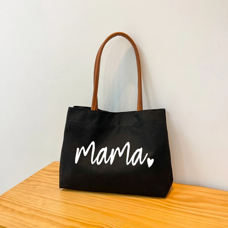 Bolso de lona negro visto de frente con diseño de impresión de letras