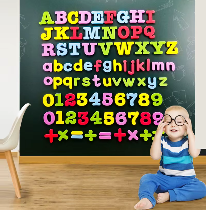 Niño formando palabras con letras magnéticas en refrigerador