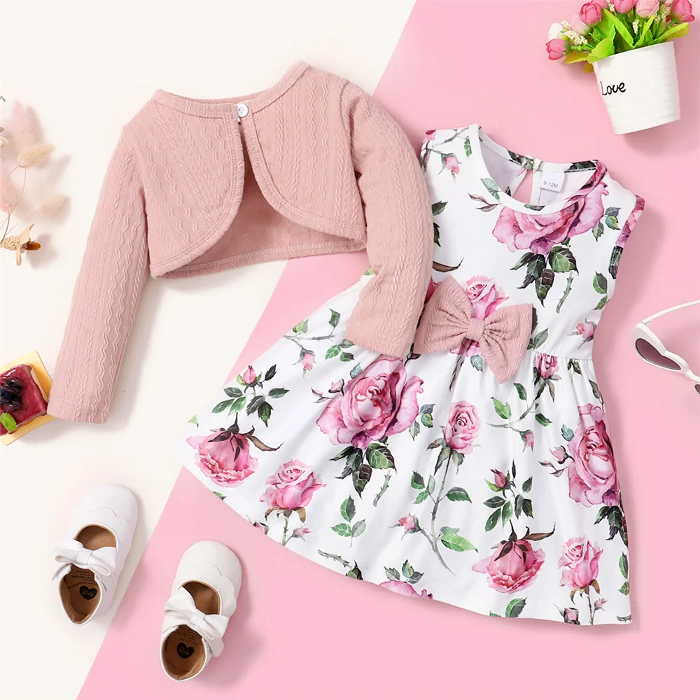 Abrigo acanalado y vestido floral puestos sobre una silla infantil