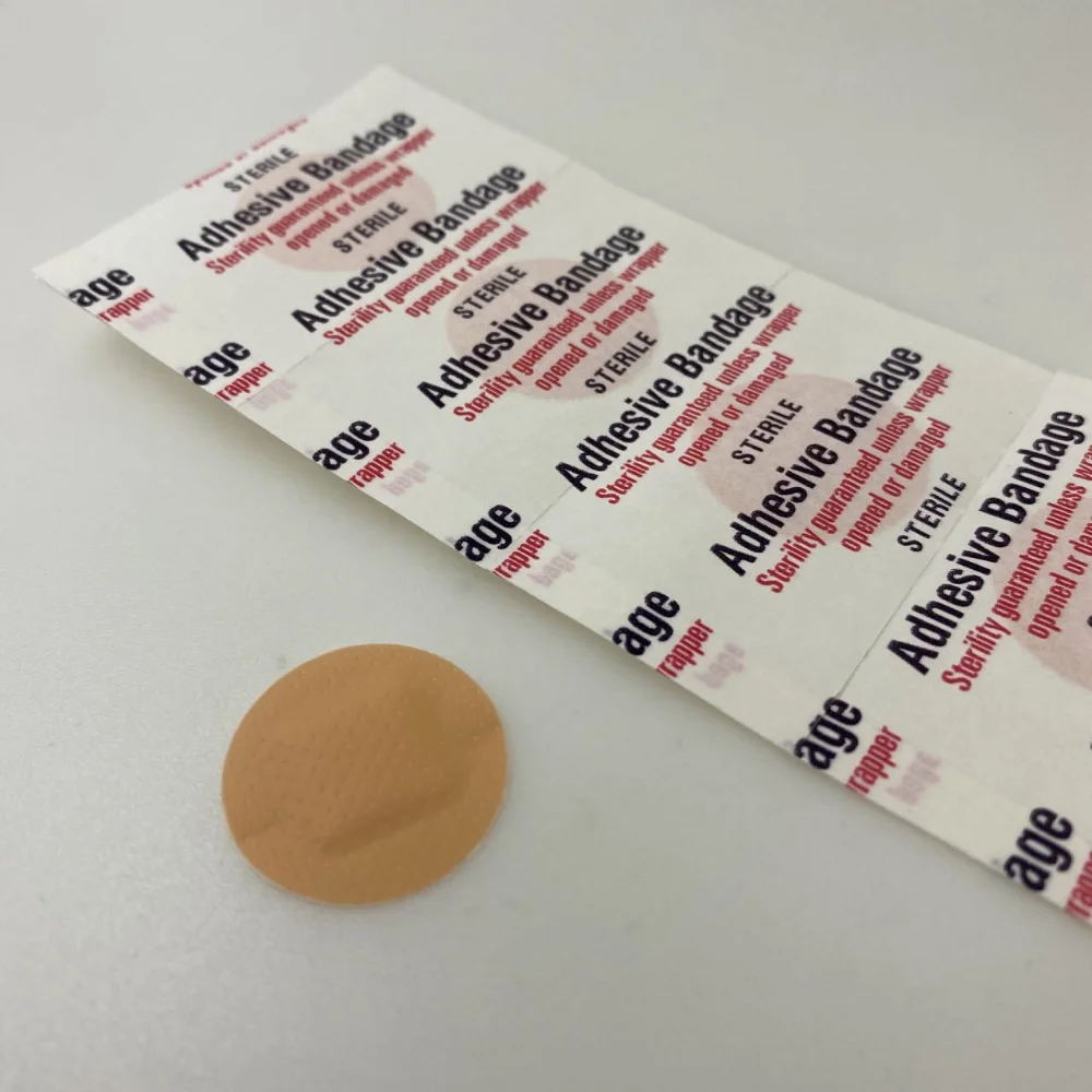 Mano retirando el papel protector de una tirita adhesiva