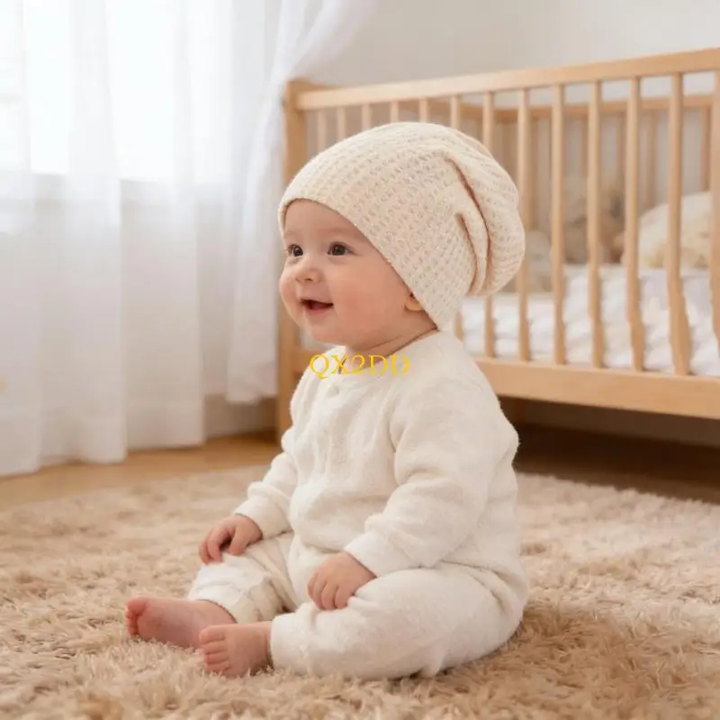 Gorro pliegado junto a otros accesorios de bebé en una cesta