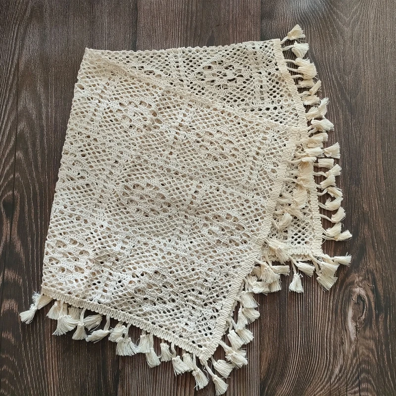 Manta de algodón con borlas Vintage extendida sobre superficie lisa