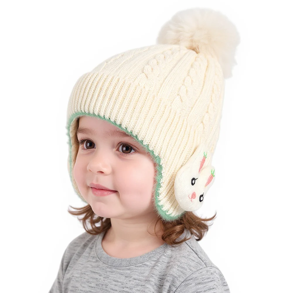 Niño jugando en la nieve con el gorro puesto