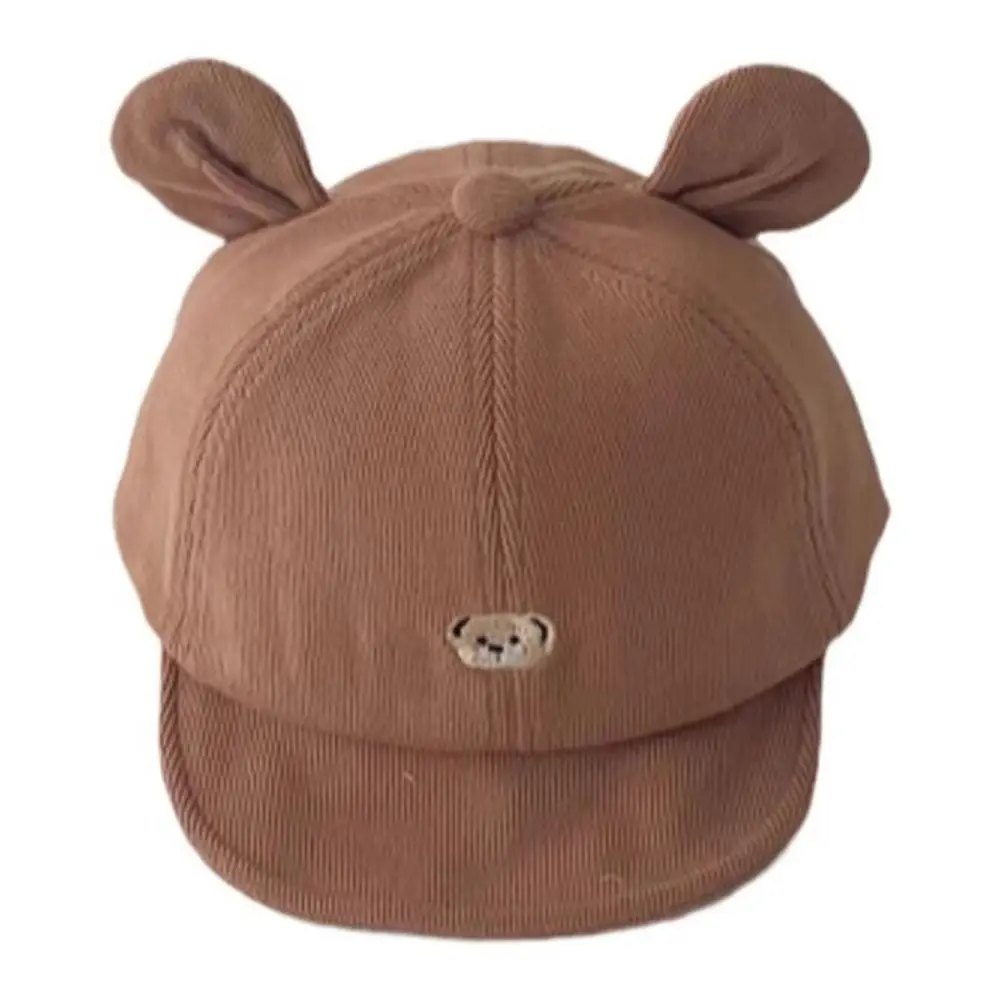 Gorra infantil con diseño de oso en color beige al aire libre