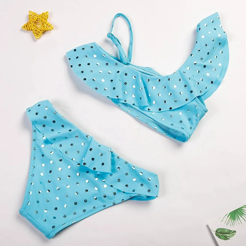 Niña jugando en la piscina con bikini de lunares
