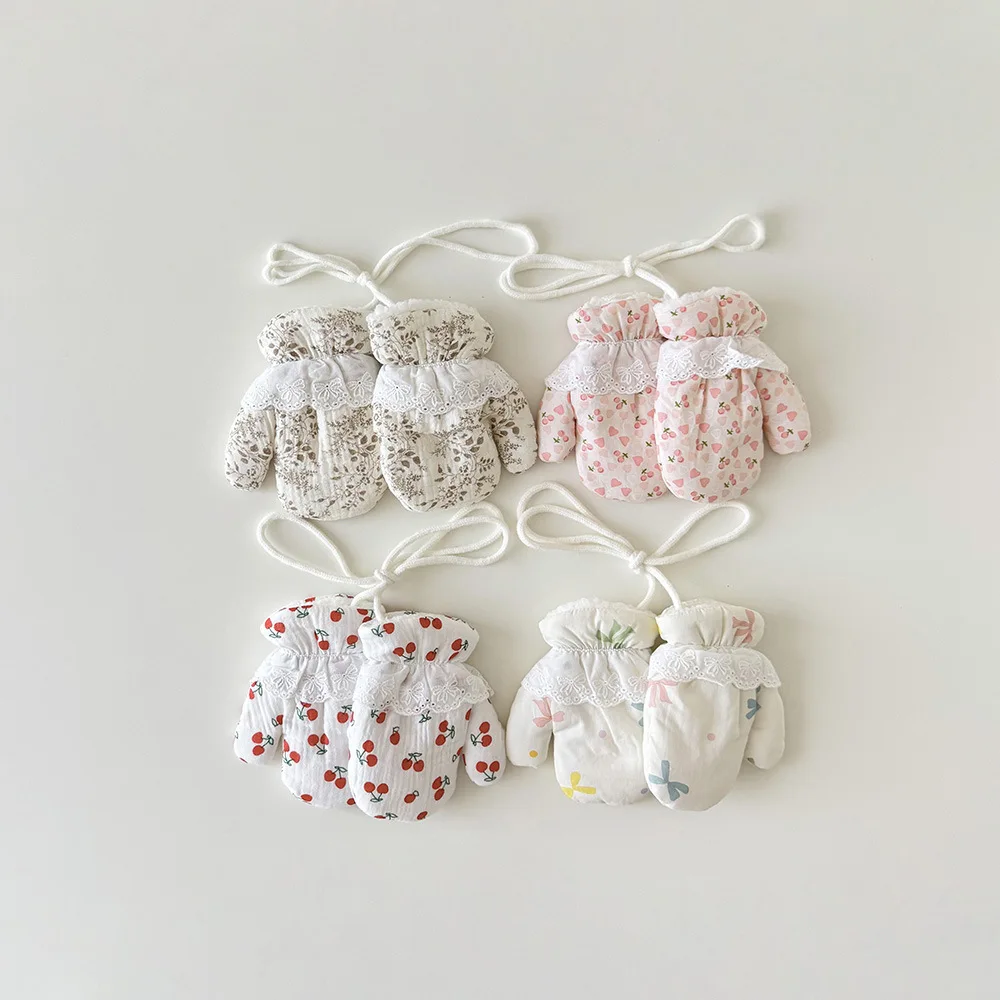Detalle de encaje y estampado floral en manoplas infantiles