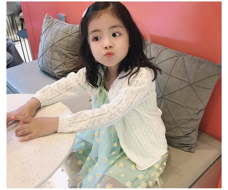 Niña jugando con el cárdigan puesto