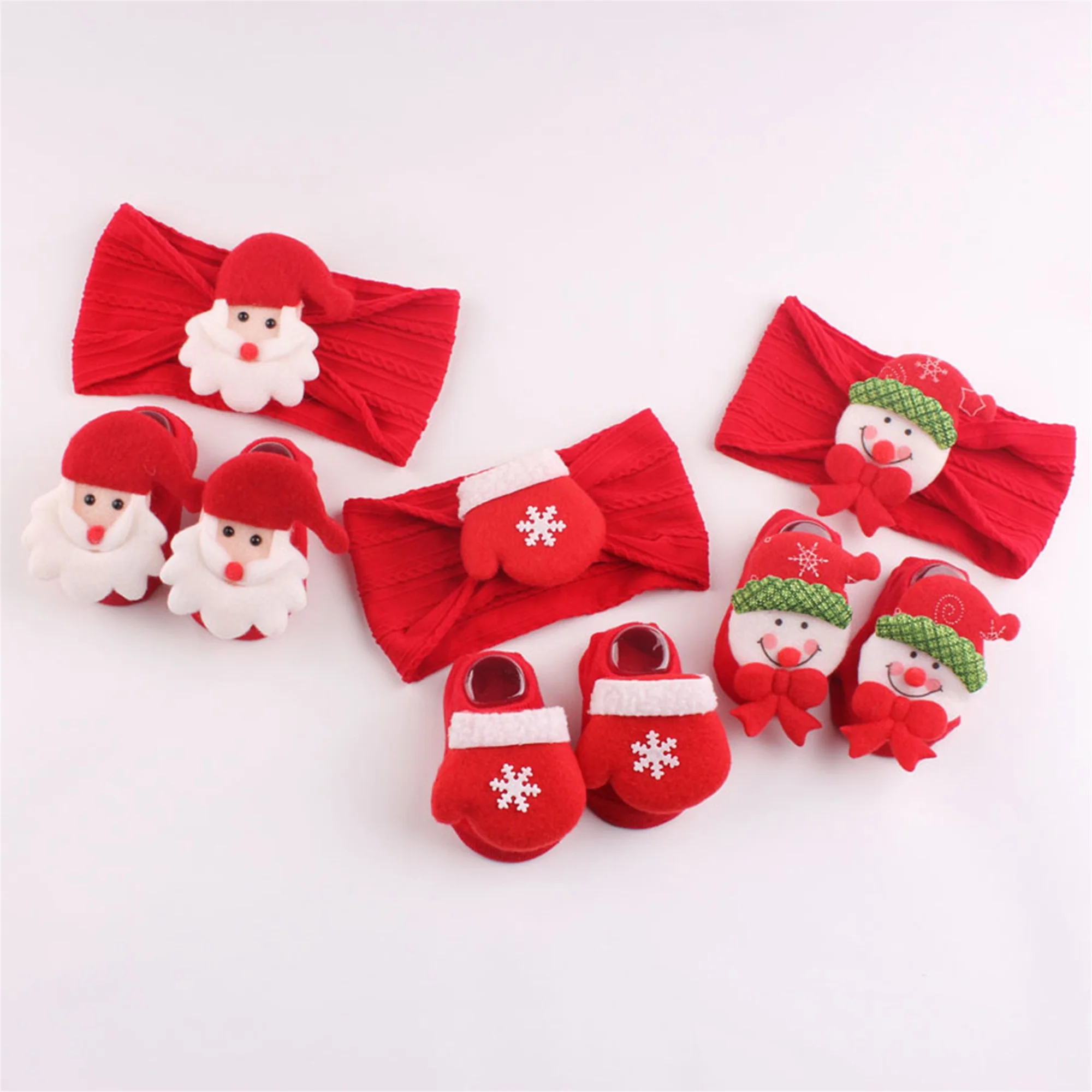 Calcetines y diadema navideños para bebé sobre fondo rojo