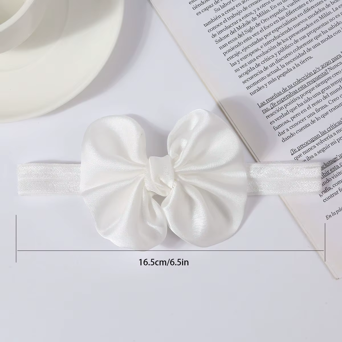 Diadema amarilla con lazo sobre ropa blanca