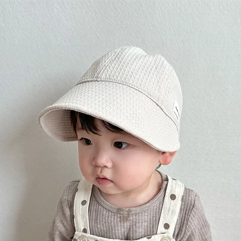 Niña usando la gorra en la playa
