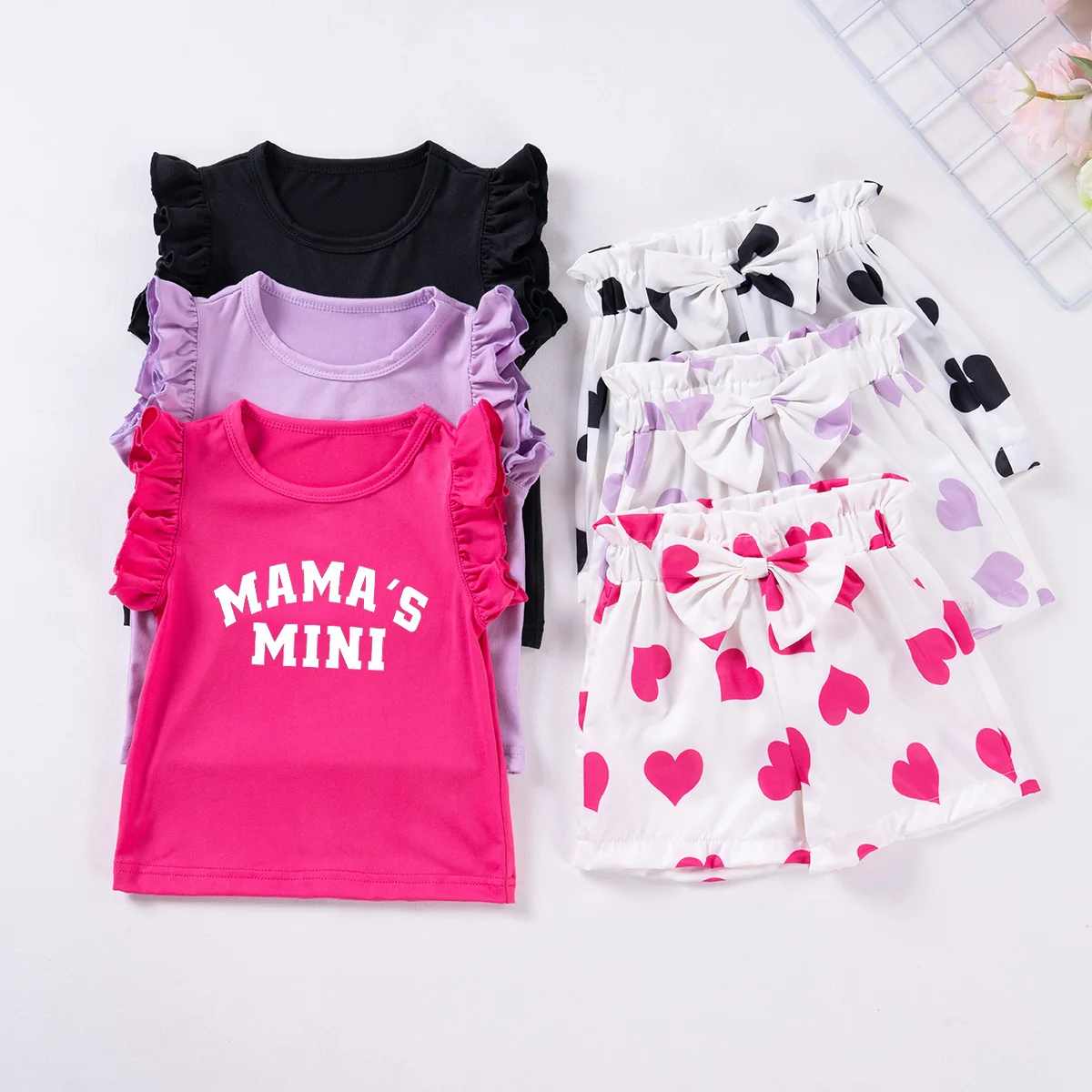 Niña vistiendo el conjunto estampado de dos piezas con chaleco y top de volantes
