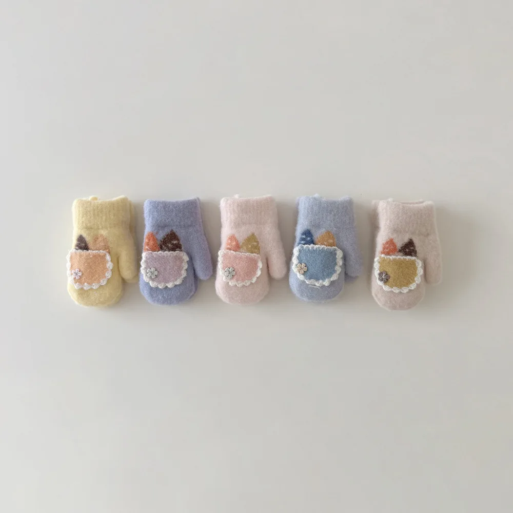 Manos de bebé con manoplas rosadas y diseño de conejito