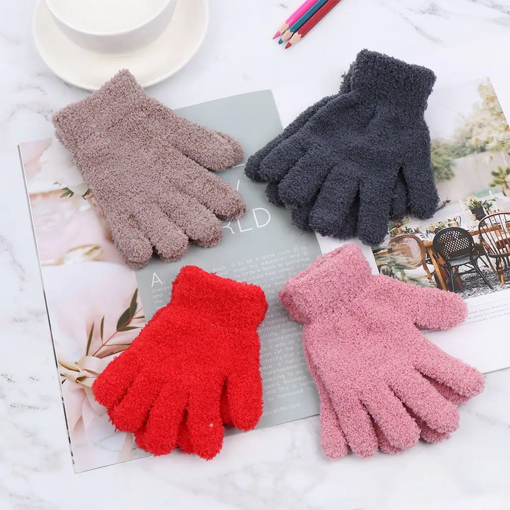 Niña usando guantes en el parque invernal