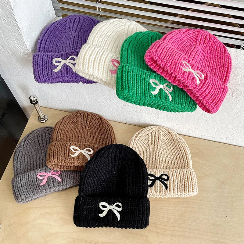 Gorro de invierno tejido con lazo bordado y orejeras para bebé