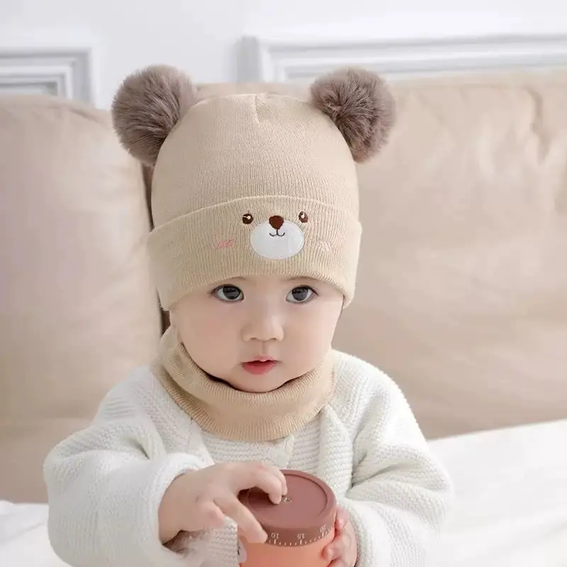Gorro y bufanda de bebé sobre superficie neutra