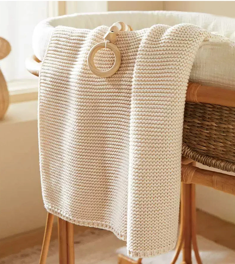 Manta tejida para bebé en color beige, ideal para cuna y cochecito
