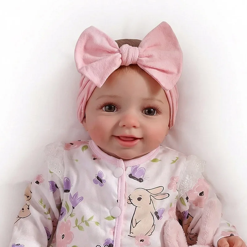 Muñeca reborn NPK con cara sonriente y cuerpo de tela suave