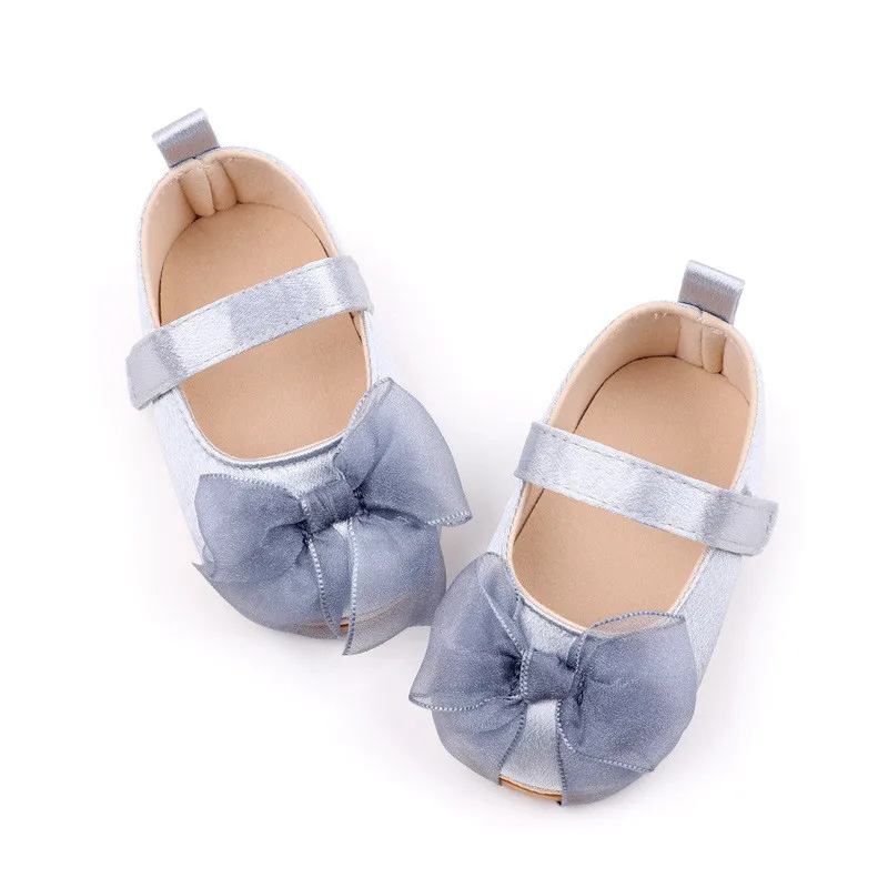 Zapatos de bebé en tono gris con lazo blanco