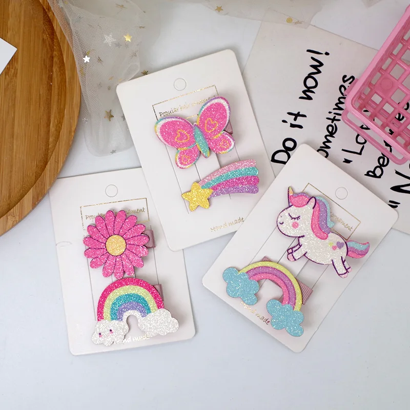 Dos horquillas coreanas brillantes con diseños de unicornio y arcoíris
