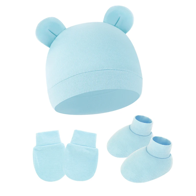 Detalle del gorro y accesorios del conjunto para 0 a 6 meses