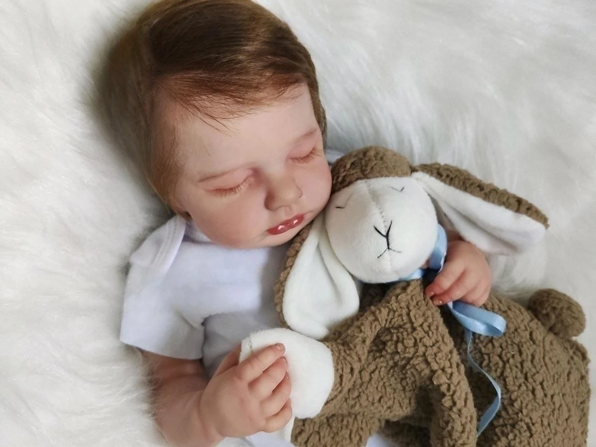 Muñeca en posición de sueño con su mantita y chupete