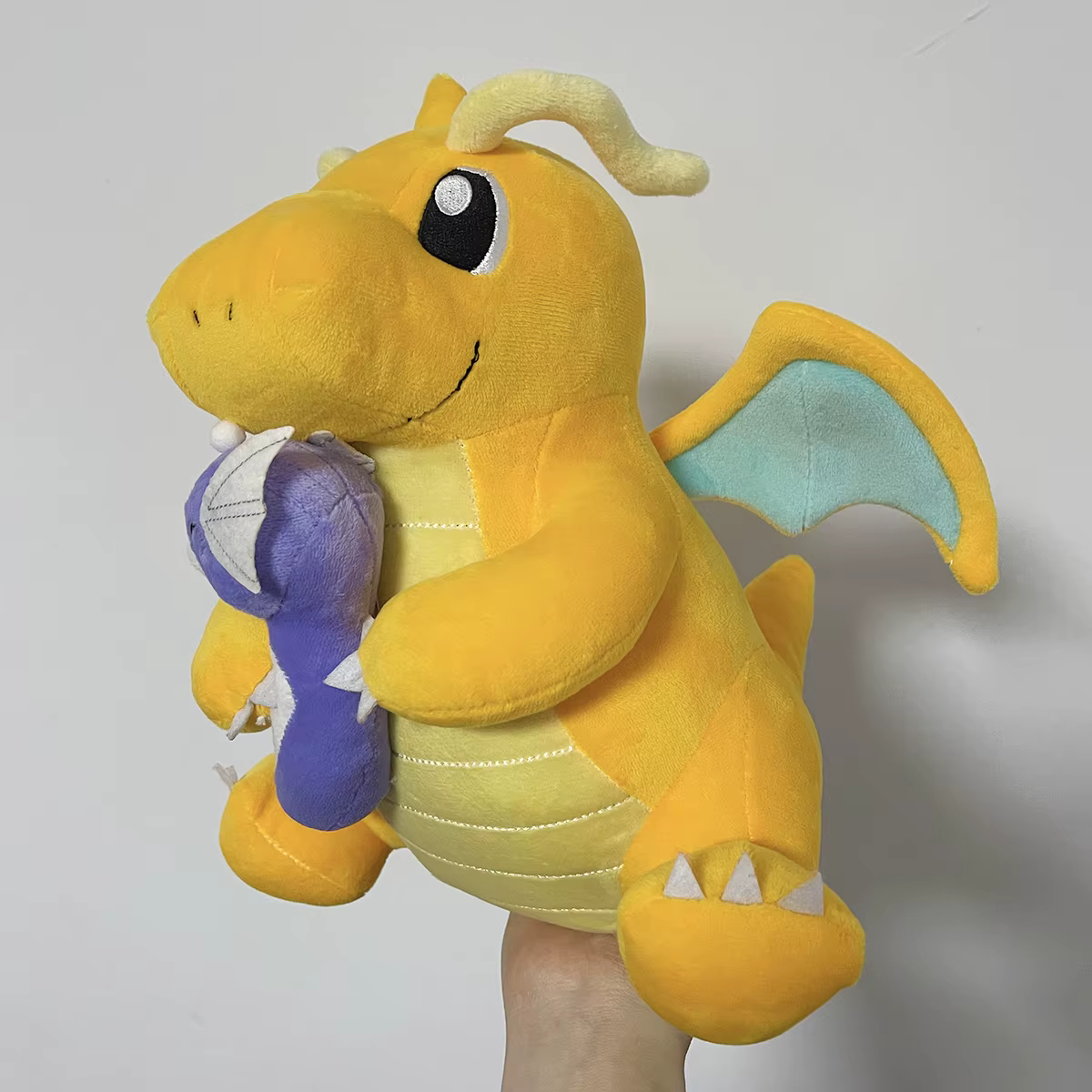 Dragonite con Dratini en postura juguetón